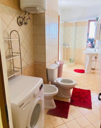 a bathroom with a toilet and a washing machine at Biancas House in Lezhë