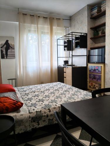 a bedroom with a bed and a table and a window at Greenhouse Torino in Turin