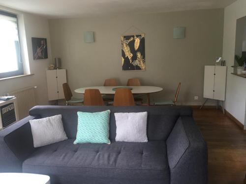 un soggiorno con un divano blu e un tavolo di Maison de village près de Colmar de 90 m2 a Horbourg