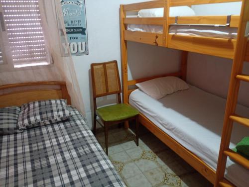 ein kleines Zimmer mit einem Etagenbett und einem Stuhl in der Unterkunft Piso, Bonito,Acogedor y Barato in Castellón de la Plana