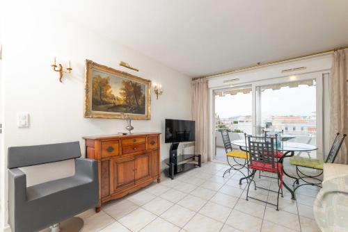 a living room with a table and a dining room at Cœur de Cannes Élégance & Détente avec Terrasse in Cannes