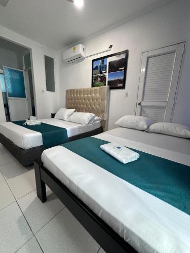 a hotel room with two beds with green sheets at SGH Rodadero Suites in Santa Marta