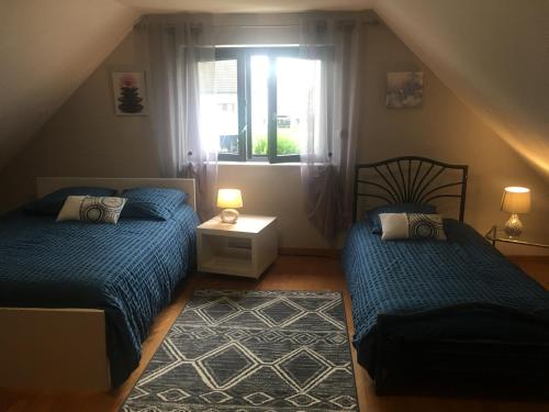 una camera da letto con due letti e una finestra di Maison de village près de Colmar de 90 m2 a Horbourg