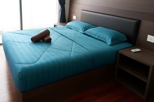 マラッカにあるTranquil Seaview 2-Bedroom Luxury Retreat with Wifiのベッド1台(青い掛け布団、青い枕付)