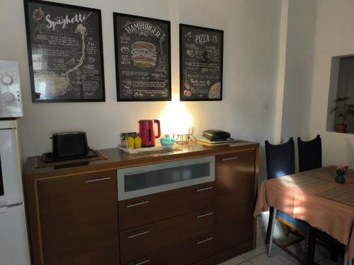 a kitchen with a wooden cabinet with a microwave and a table at Village Rákoshegy in Budapest