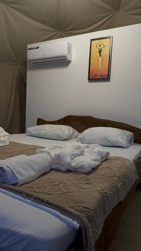 1 dormitorio con 2 camas y aire acondicionado en la pared en Premium Glamping In Akho, en Akho