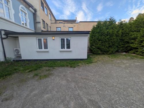 a white house with a driveway in front of it at Townhouse in the middle of Notodden city centre in Notodden