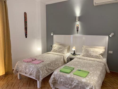 a bedroom with two beds with green and pink sheets at Luxury Apartment Ritz Carlton in Sharm El Sheikh
