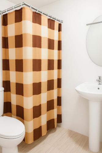 a bathroom with a toilet and a shower curtain at 1bedroom Lot8 condo in Cebu City