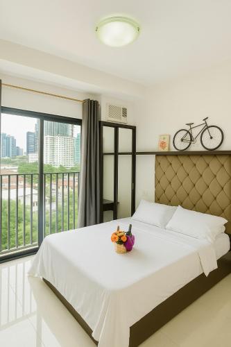 a bedroom with a large white bed and a balcony at 1bedroom Lot8 condo in Cebu City