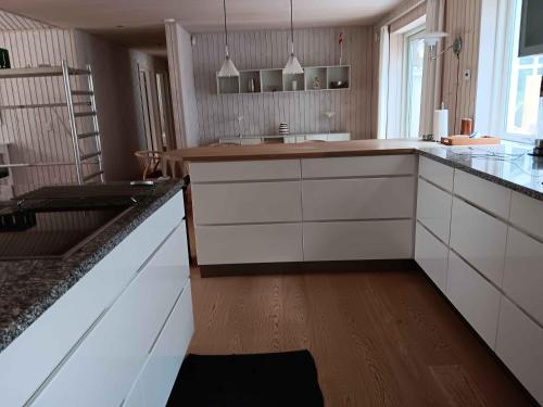 a kitchen with white cabinets and a wooden floor at Large Holiday Home Close To Nature in Tikøb