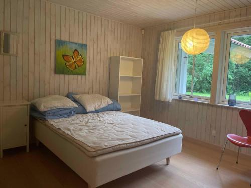 a bedroom with a bed and a window at Large Holiday Home Close To Nature in Tikøb