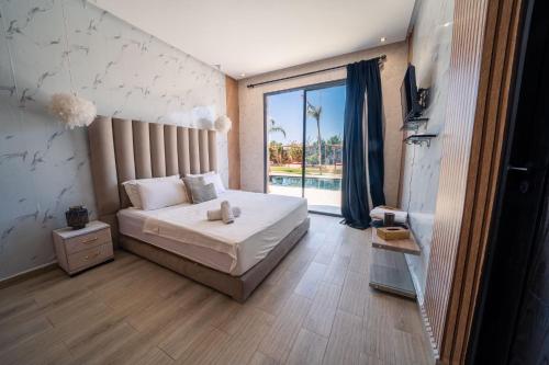 a bedroom with a bed and a large window at Viva La Villa in Marrakech