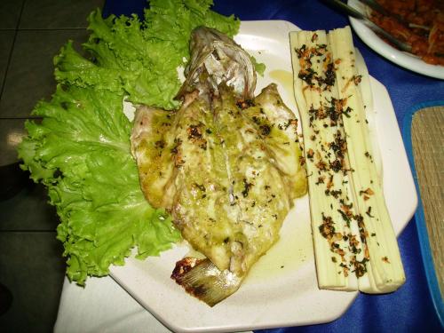 a white plate of food with lettuce and meat at Hotel Marina Clube de Pesca in Cananéia