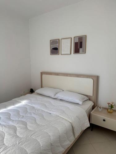 a bed in a bedroom with two pictures on the wall at Fès comfort stay in Fès