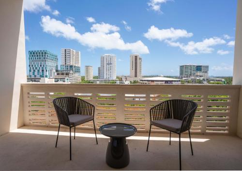 two chairs and a table on a balcony with a city skyline at City escape in Cancún