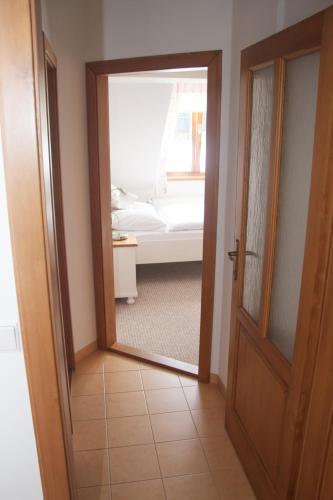 a door with a mirror in a room with a bed at Farma Basarovi in Prosečné