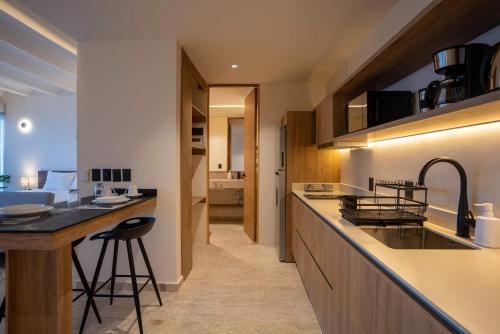 a kitchen with a counter and a bar with a sink at Nomad Studio Fast WiFi and Rooftop Pool in Cancún