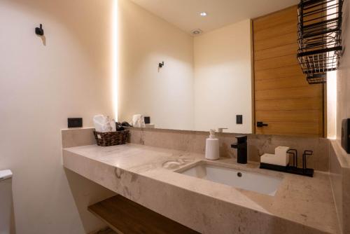 a bathroom with a large marble sink with a mirror at Nomad Studio Fast WiFi and Rooftop Pool in Cancún