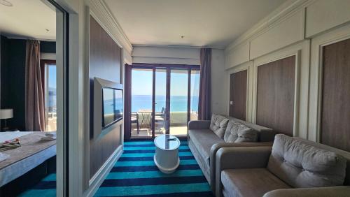 a hotel room with a couch and a view of the ocean at Azure Coast Residence Budva in Becici