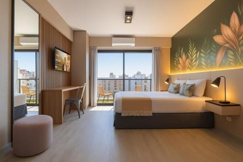 Una habitación de hotel con una cama, un escritorio y una ventana. en Deluxe Apartments in Downtown by BueRentals, en Buenos Aires