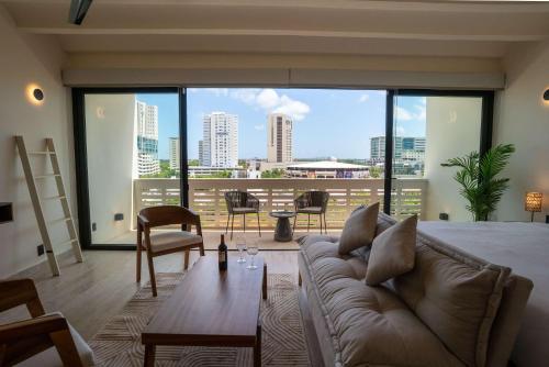 a living room with a couch and a large window at Remote Work Ready Studio with Coworking and Views in Cancún
