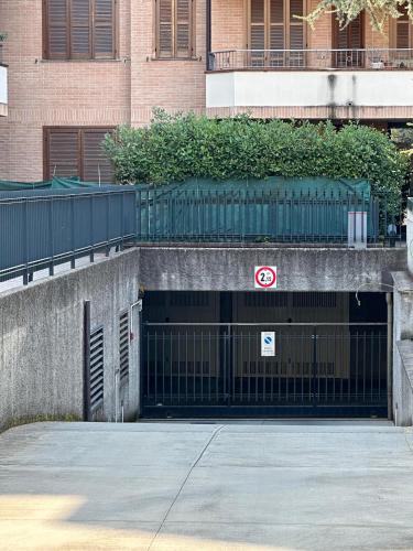 a gate to a parking lot with a building at Garden Home "Milan-Rho fair" in Solaro