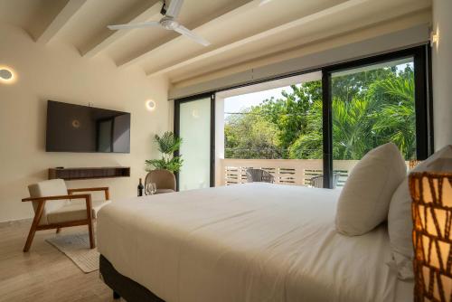 a bedroom with a white bed and a large window at Versatile Studio Cowork Fast WiFi and Prime Location in Cancún
