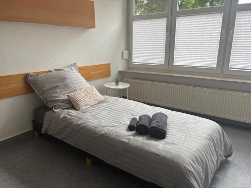a bedroom with a bed with two slippers on it at Gemütliche Monteurswohnungen voll möbliert & Zentral in Nentershausen
