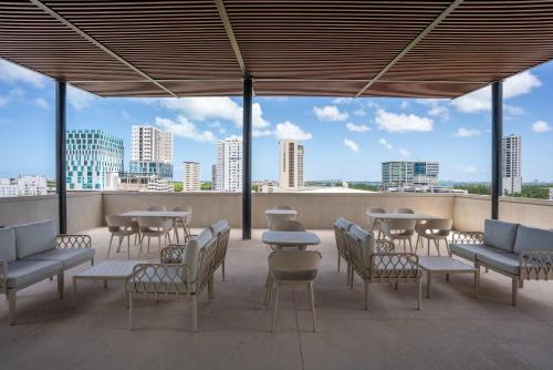 a patio with tables and chairs and a view of the city at Work and Relax Studio with Rooftop and Workspace in Cancún