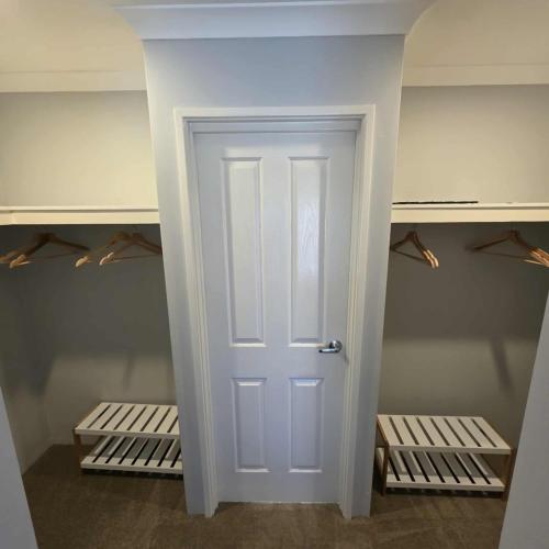 a closet with a white door in a room at Modern Bassendean Abode in Perth
