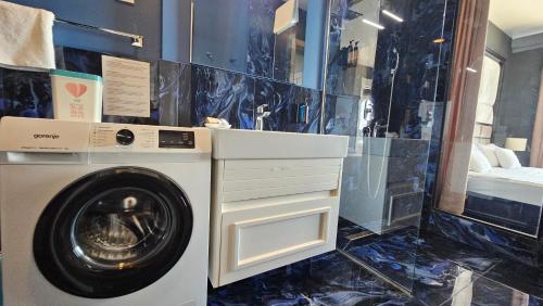 a bathroom with a washing machine in a room at Azure Coast Residence Budva in Becici