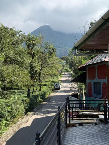 a road with a fence next to a house and a car at Sabhyata Stays Bir in Bīr