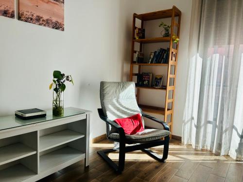 a chair sitting next to a desk with a red pillow at ROOMS Malaga Centro Jinetes in Málaga