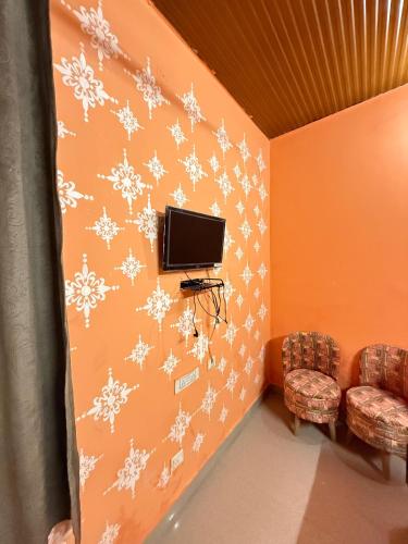 a living room with a tv and snowflake wall art at Sabhyata Stays Bir in Bīr