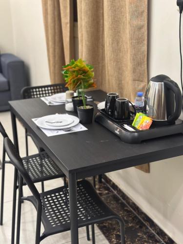 a black table with chairs and a tea set on it at شاليهات بستان الورد لبيوت العطلات in Al Shafa