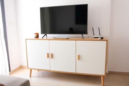 a white cabinet with a television on top of it at Ground floor apartment on the seafront with pool in Vinaròs