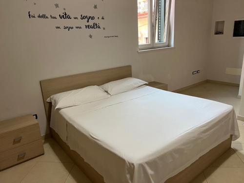 a bed in a bedroom with writing on the wall at A due passi dal Viale in Francavilla Fontana
