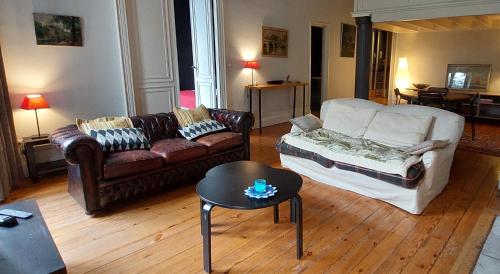 een woonkamer met een bank en een tafel bij Burdigala Homes - Appart Clemenceau in Bordeaux