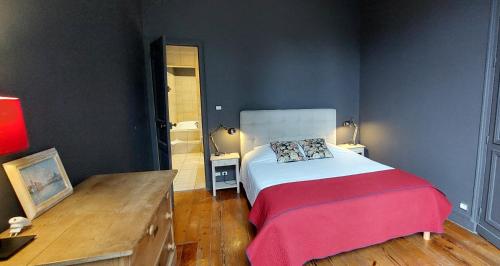een slaapkamer met een bed met een rood-witte deken bij Burdigala Homes - Appart Clemenceau in Bordeaux