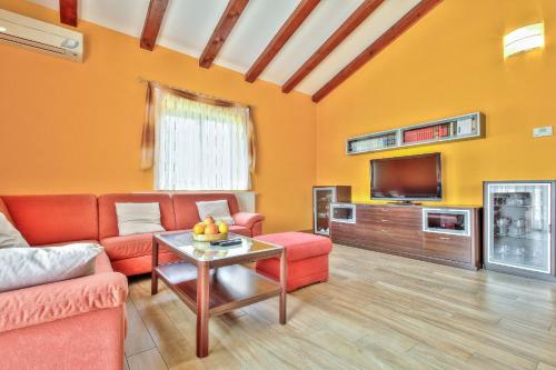 a living room with a couch and a tv at Schöne Ferienvilla Morena Mit Pool in Kaštel