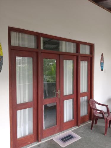 a red door with glass windows and a chair at Villa sea 40 Ambalangoda in Wenamulla
