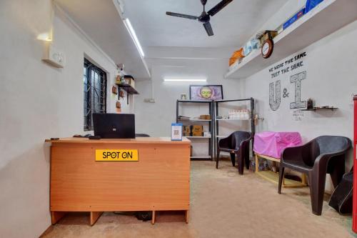 uma sala de espera com uma secretária com um computador em Hotel O U & I LIVINGS em Goa