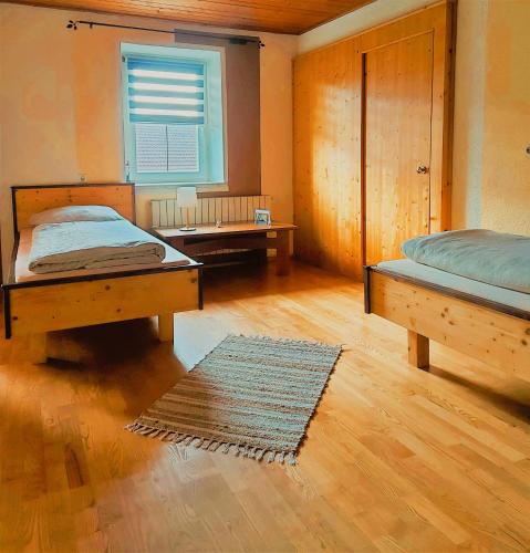 a bedroom with two beds and a window and a rug at Appartement Jakalar in Vils