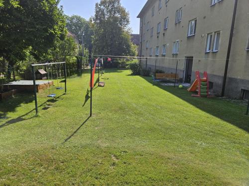 a yard with a swing set in the grass at Apartmán Via Piaristi - self check in in Příbor