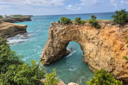 an arch in the rocks on the ocean at Oceanfront Villa with Pool, Jacuzzi and Kayaks on Anguilla Island in Island Harbour