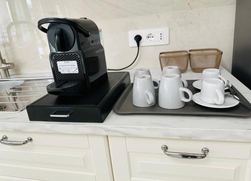 a black phone on a tray on a counter with mugs at Domus Park Avenue in Rome