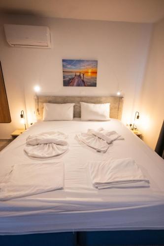 a white bed with two towels on top of it at Luca Apts Napa in Ayia Napa