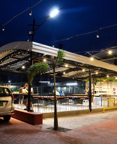 a building with people sitting outside at night at Summit Resort and Sports Hub 