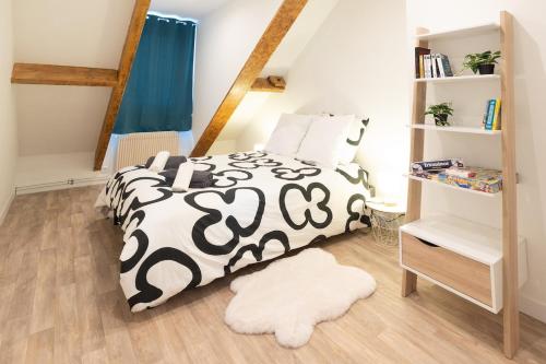 a bedroom with a bed with a black and white comforter at L'Eclat des Halles - Hypercentre in Amiens